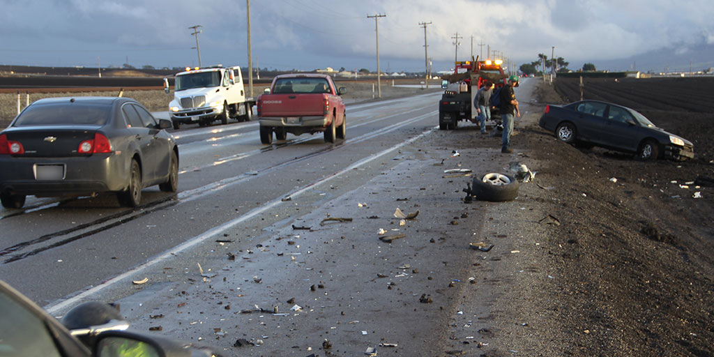 Road Traffic Incident Risk Mitigation Technologies-Car wreck on the side of the road with a tow truck and debris on the road